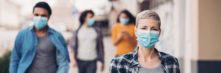 Group of people walking in public wearing masks