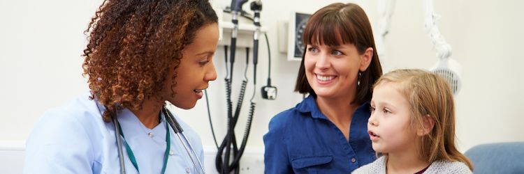 Family nurse practitioner examining little girl sitting next to her mom