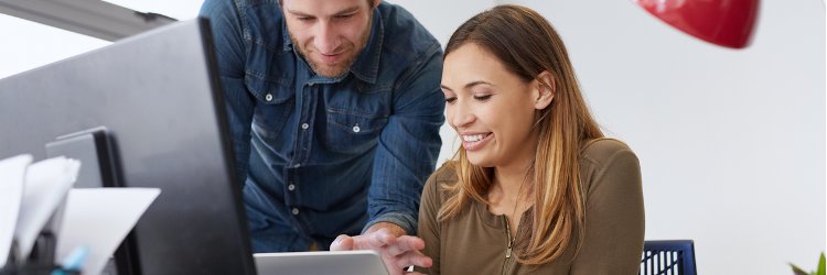 Two digital marketing professionals looking over data on a computer