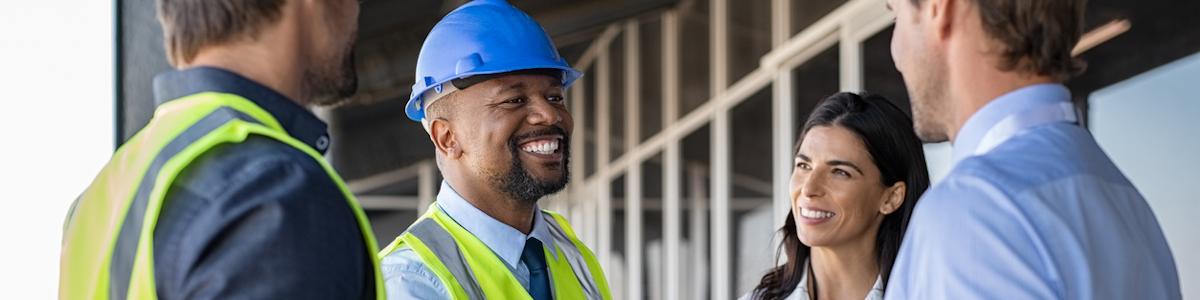 Construction site supervisor talking with engineer and construction worker