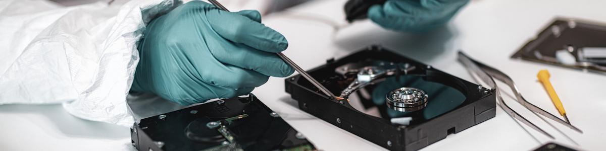 Forensic technician examining a hard drive for evidence
