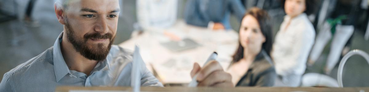 Engineer making notes on a whiteboard in a meeting