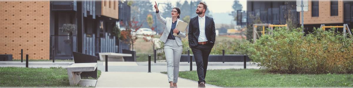 Photo of two real estate developers walking through a building complex